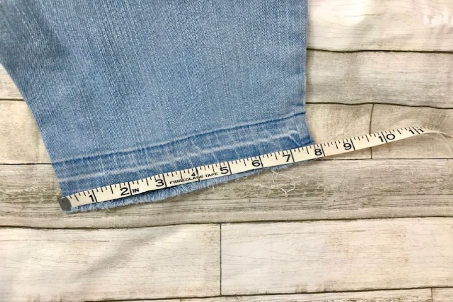measuring raw edge of jeans hem for our simple sewing hack