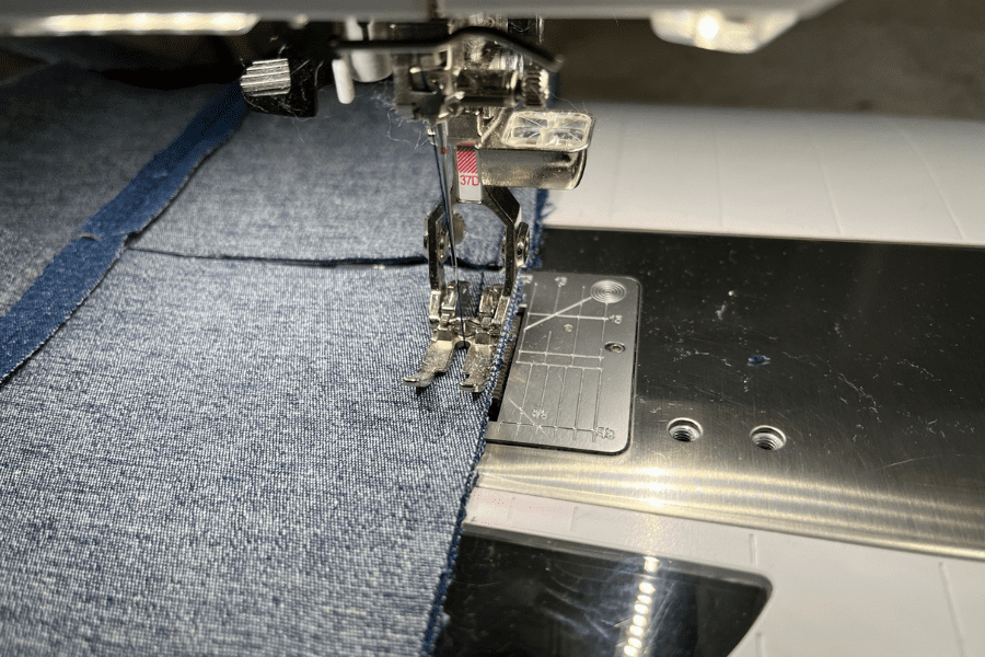 sewing denim squares of patchwork for upcycled sewing project